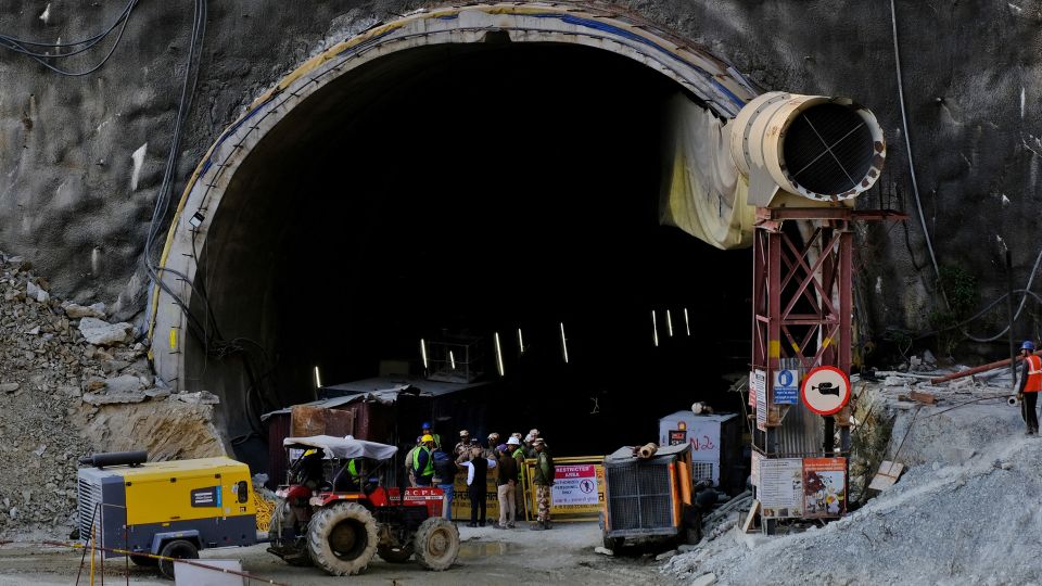 Members of rescue teams stand at the entrance of a tunnel where road workers are trapped after a portion of the tunnel collapsed in Uttarakhand, India.